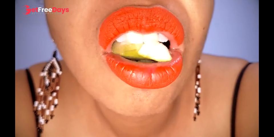Ebony MILF with red lips eats a fruit suggestively